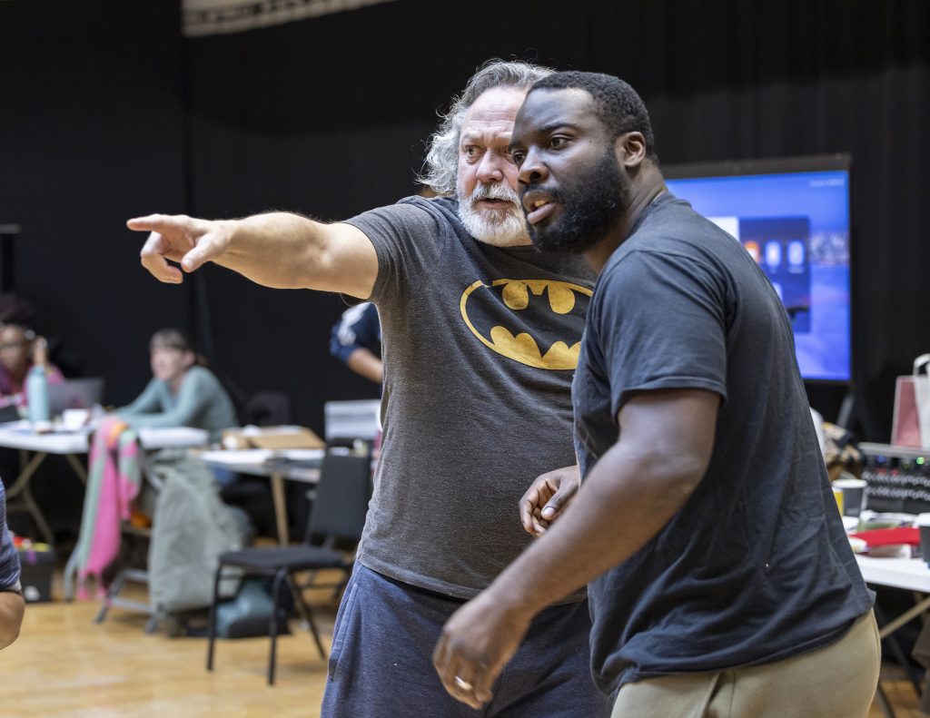 two people at a theatre rehearsal, with one pointing 