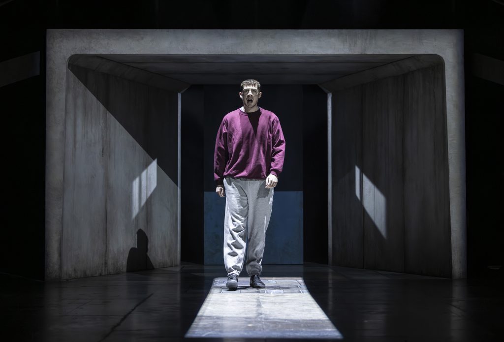 an actor on a theatre stage looking shocked
