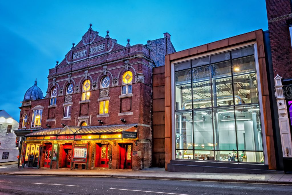 a large brick building with an extension attached with a glass front