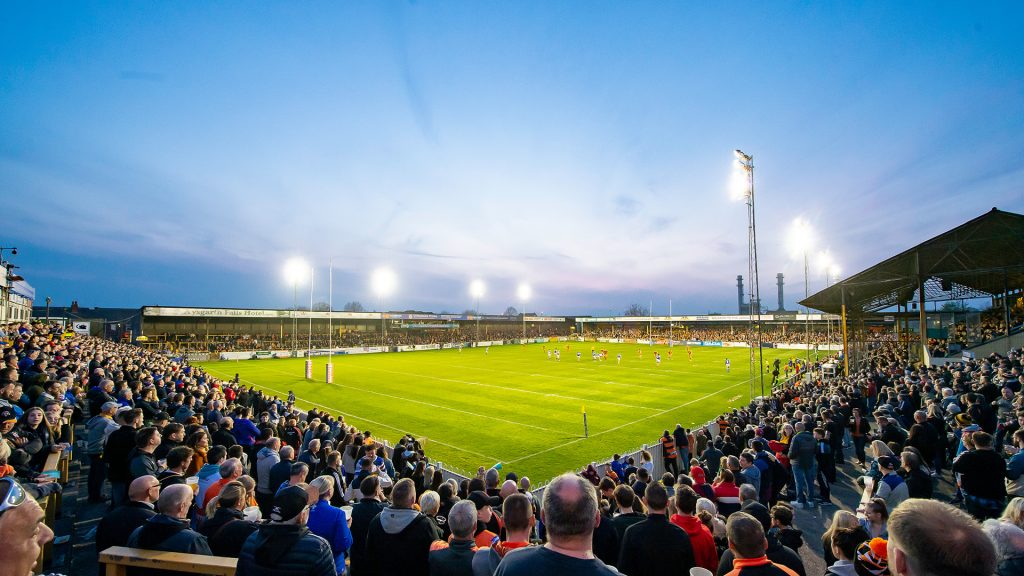 a rugby pitch with a game on and a large crowd