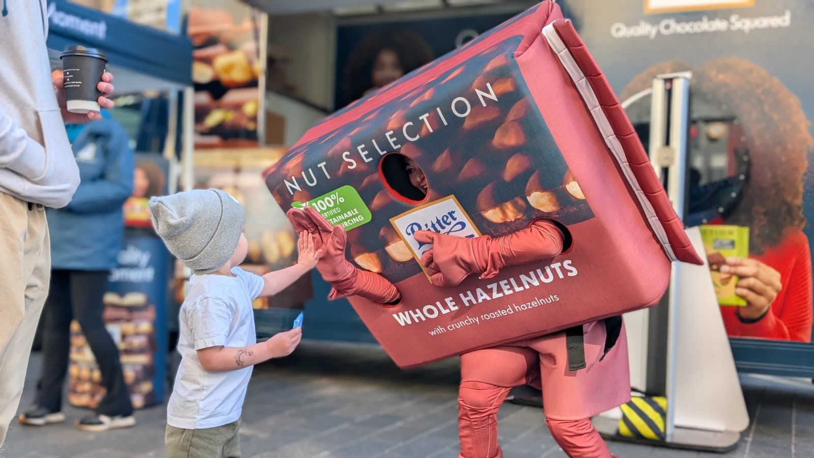 a person dressed up as a bar of ritter branded chocolate high fiving a child