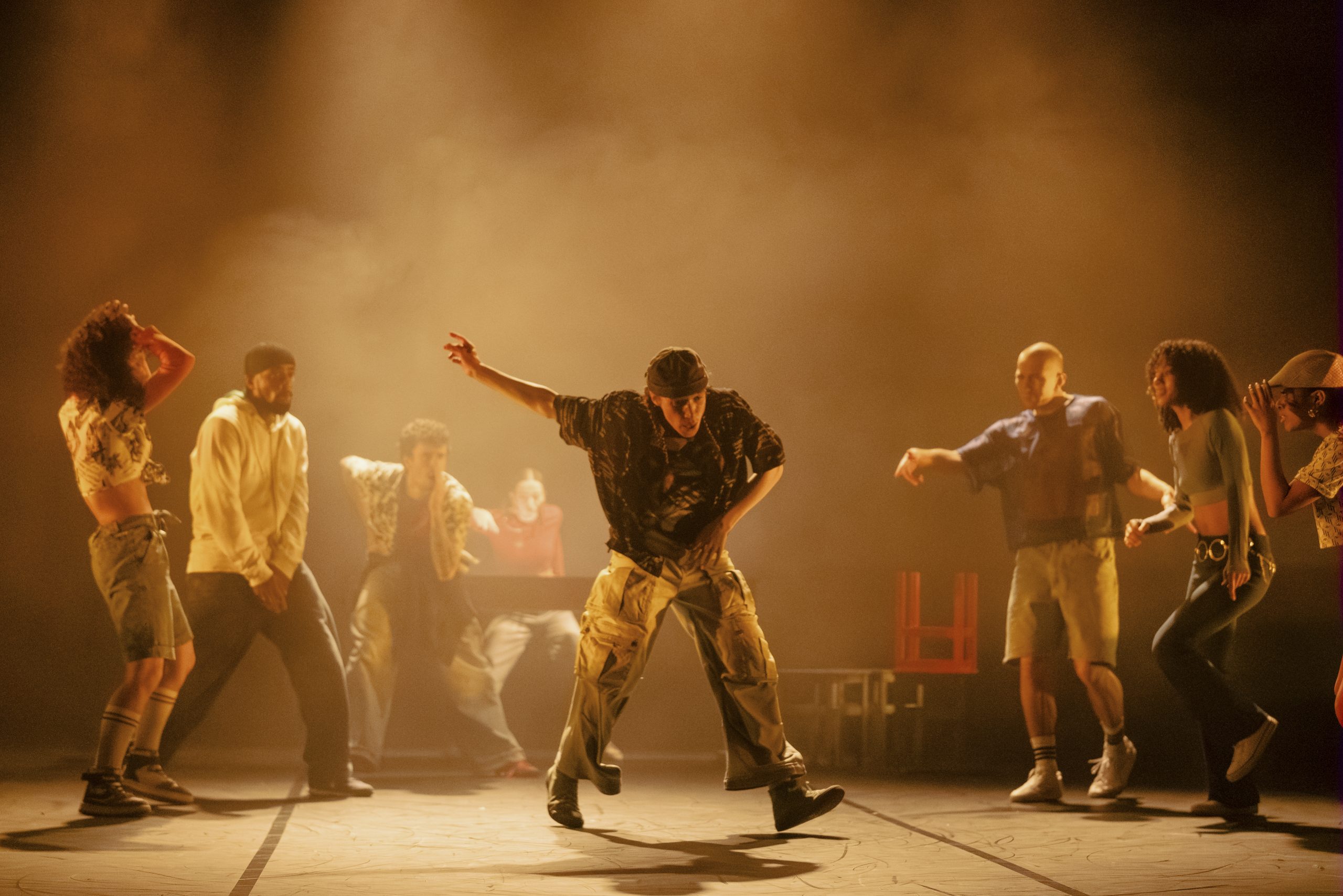 a group of dancers on a low lit stage