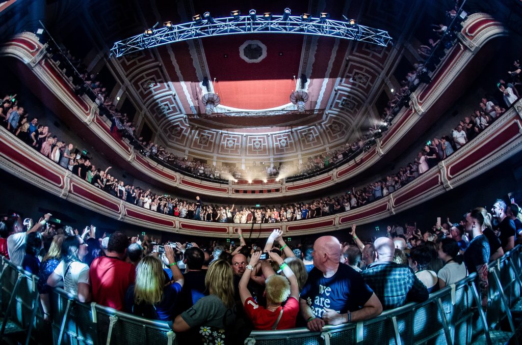 an indoor victorian theatre with a large crowd of people