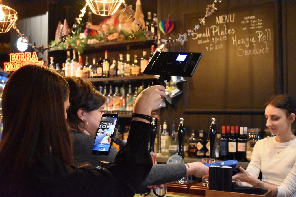 Women working at the bar being filmed by members of the Women Friendly Leeds team.