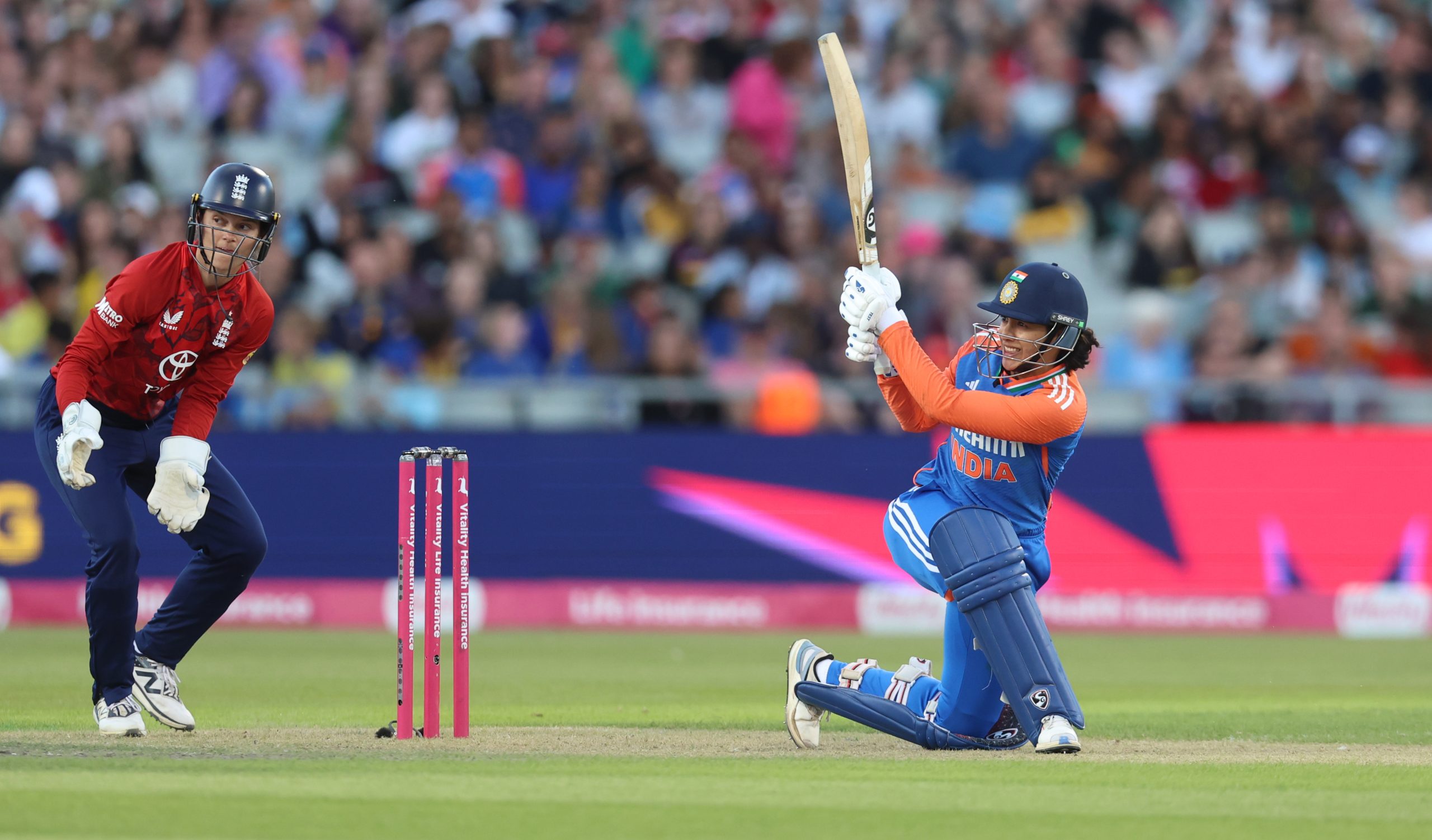 two women playing cricket in a stadium