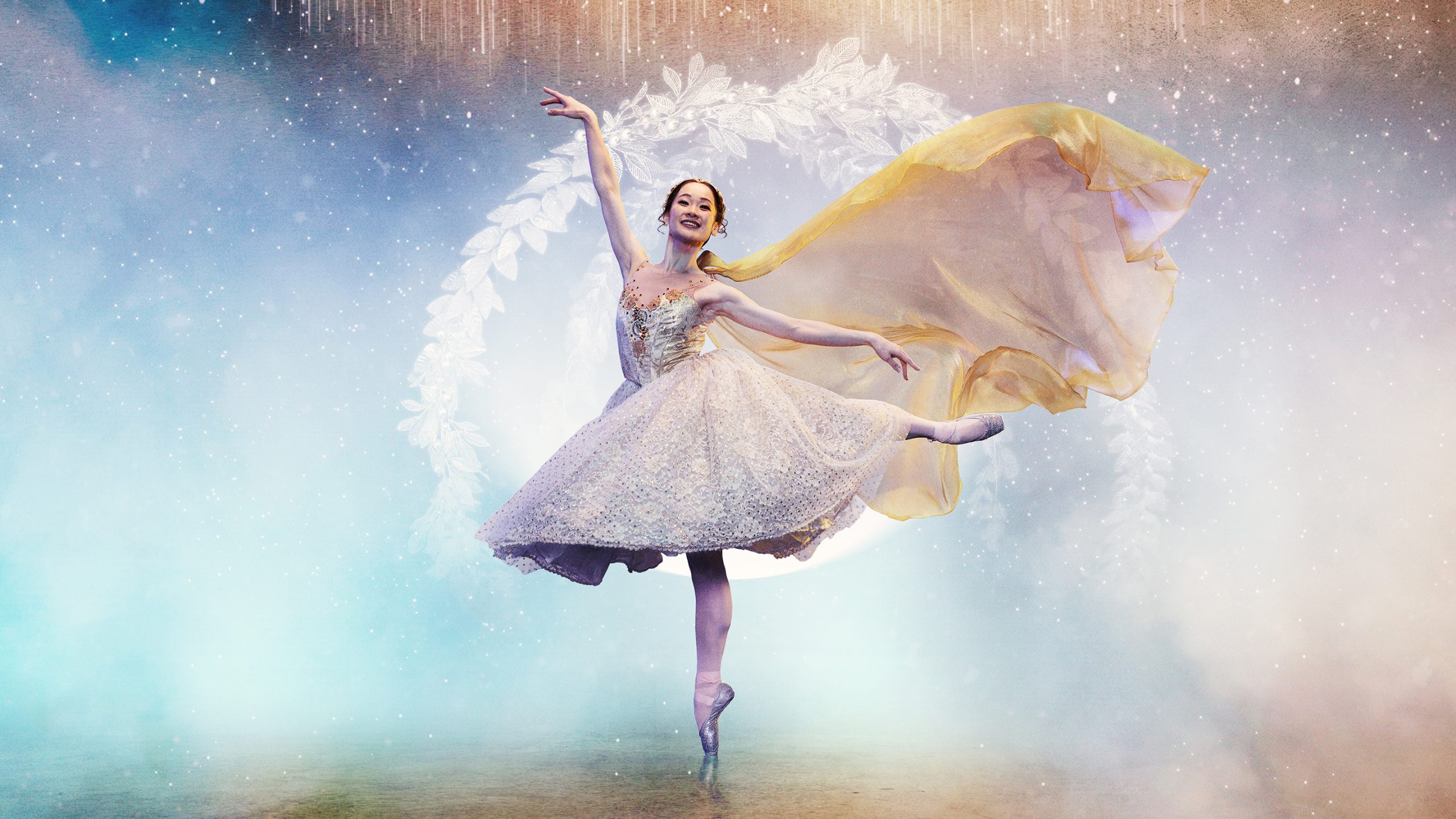 a ballet dancer in a large white tutu dress en pointe on one leg with a background thats glittery