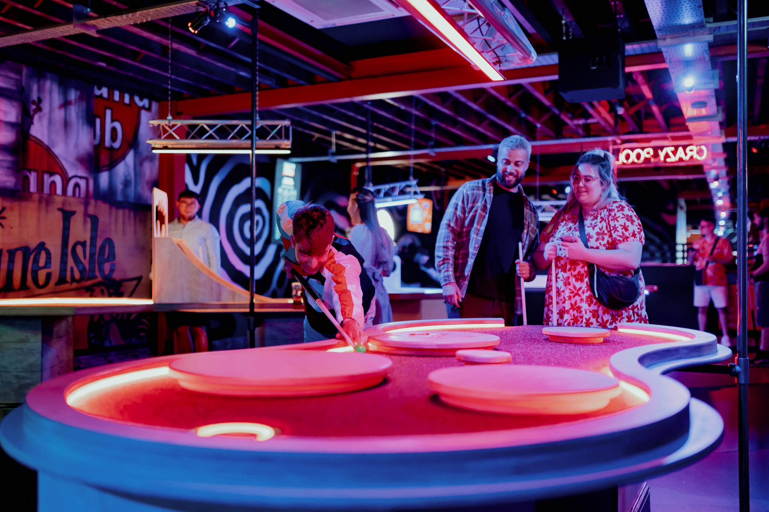 a family playing pool on a neon table