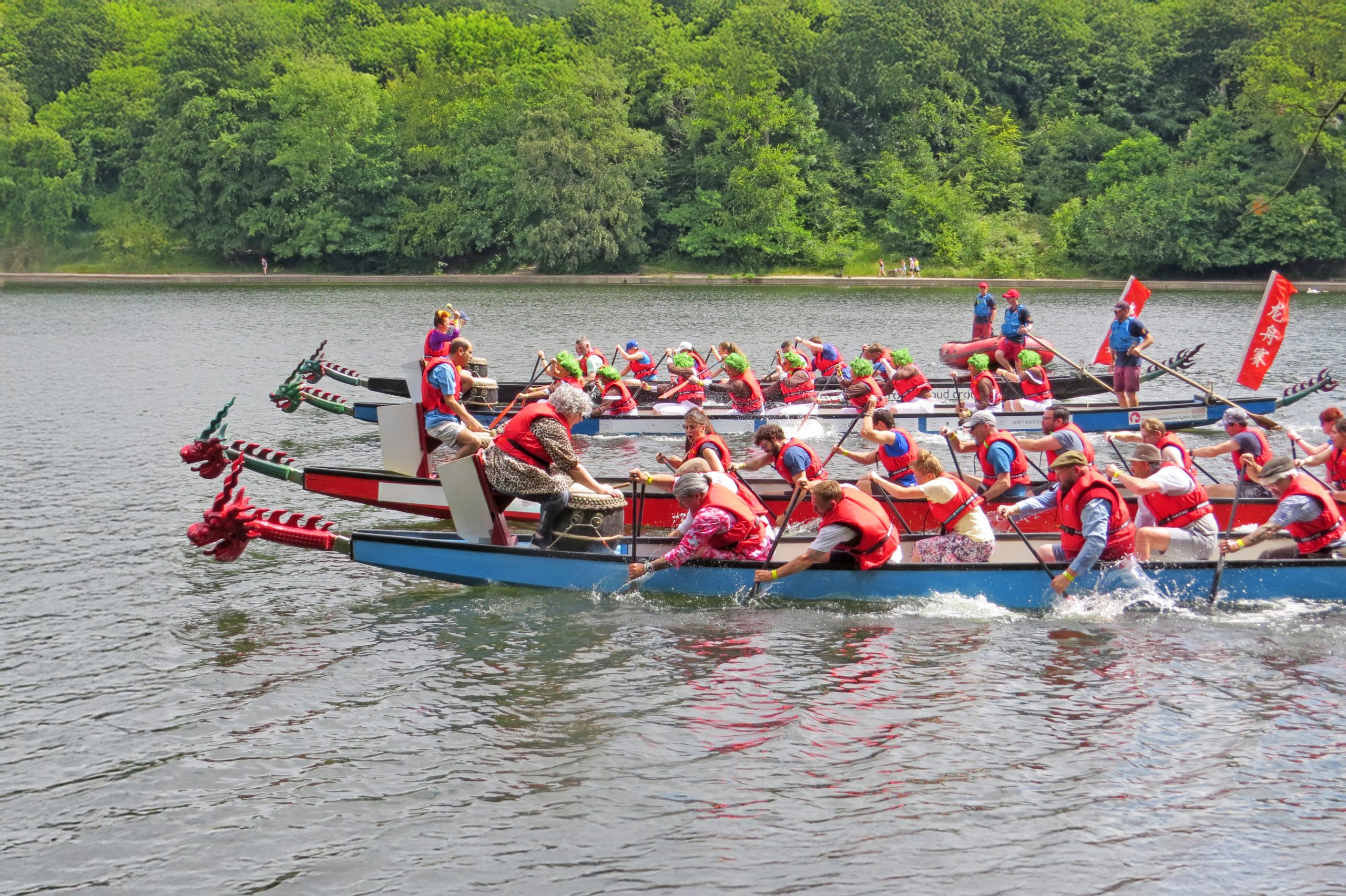 a lake with two long boats racing, people rowing