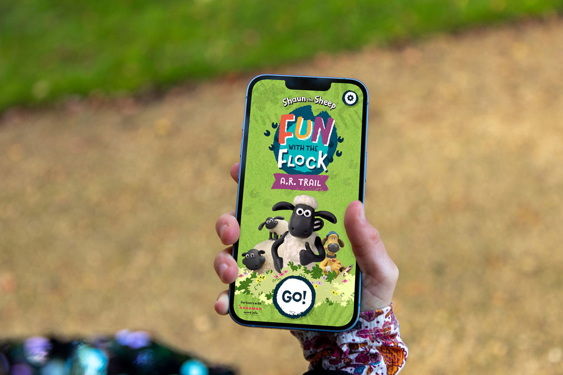 someone holding a smart phone with an app open showing shaun the sheep