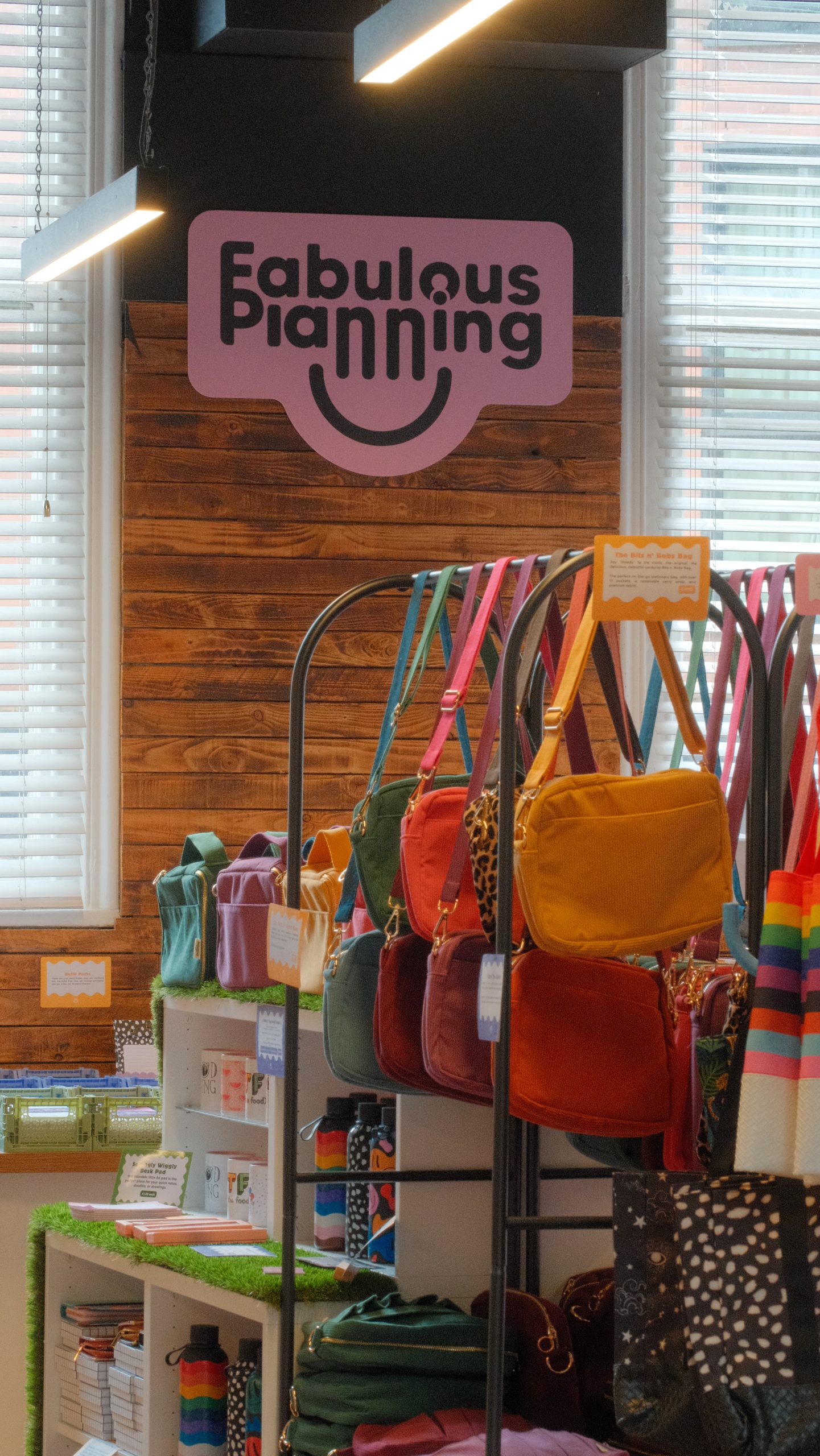 the interior of a shop with brick walls, displays of bags hung up and other items