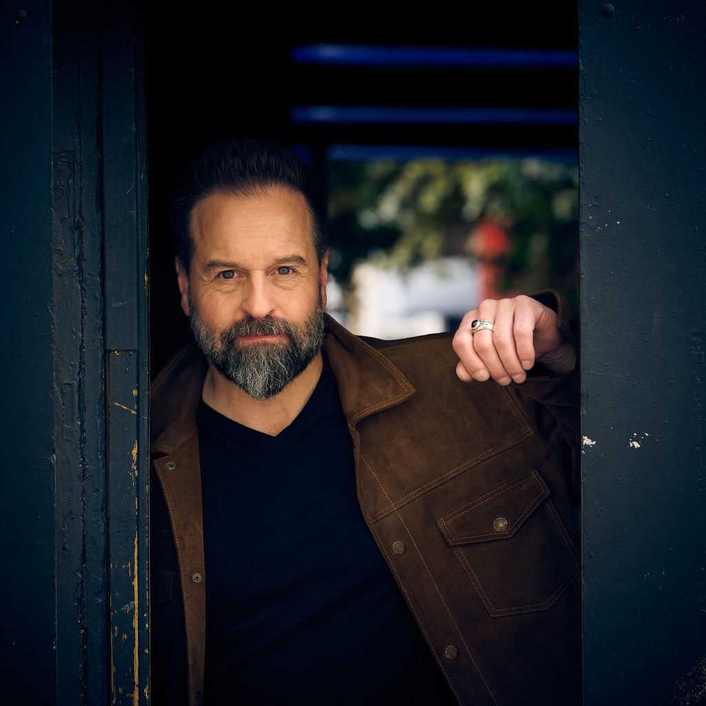 a man  posing stood in a doorway leaning
