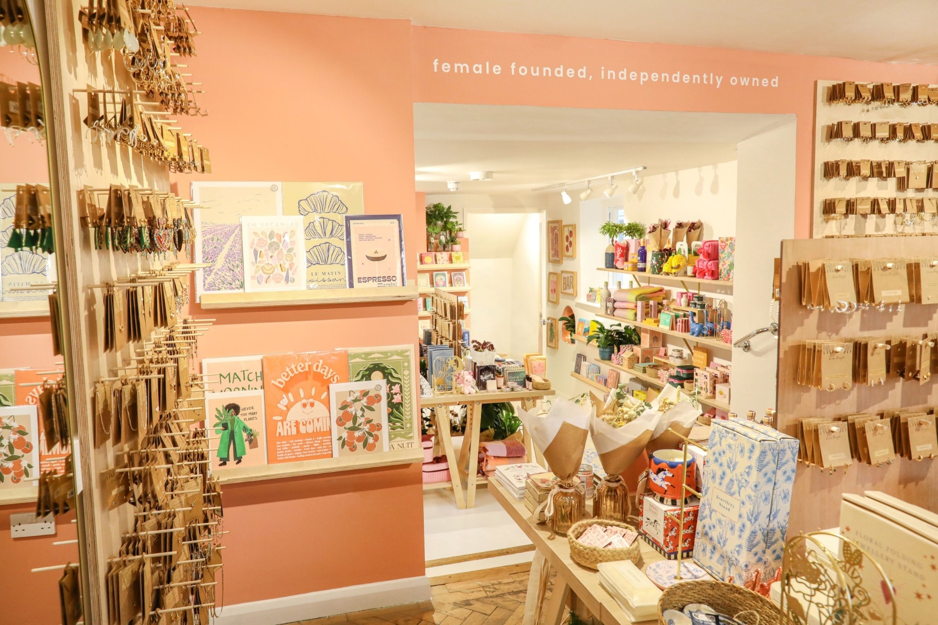 the interior of a shop with bright lights a shelf of books and tables with many objects on them