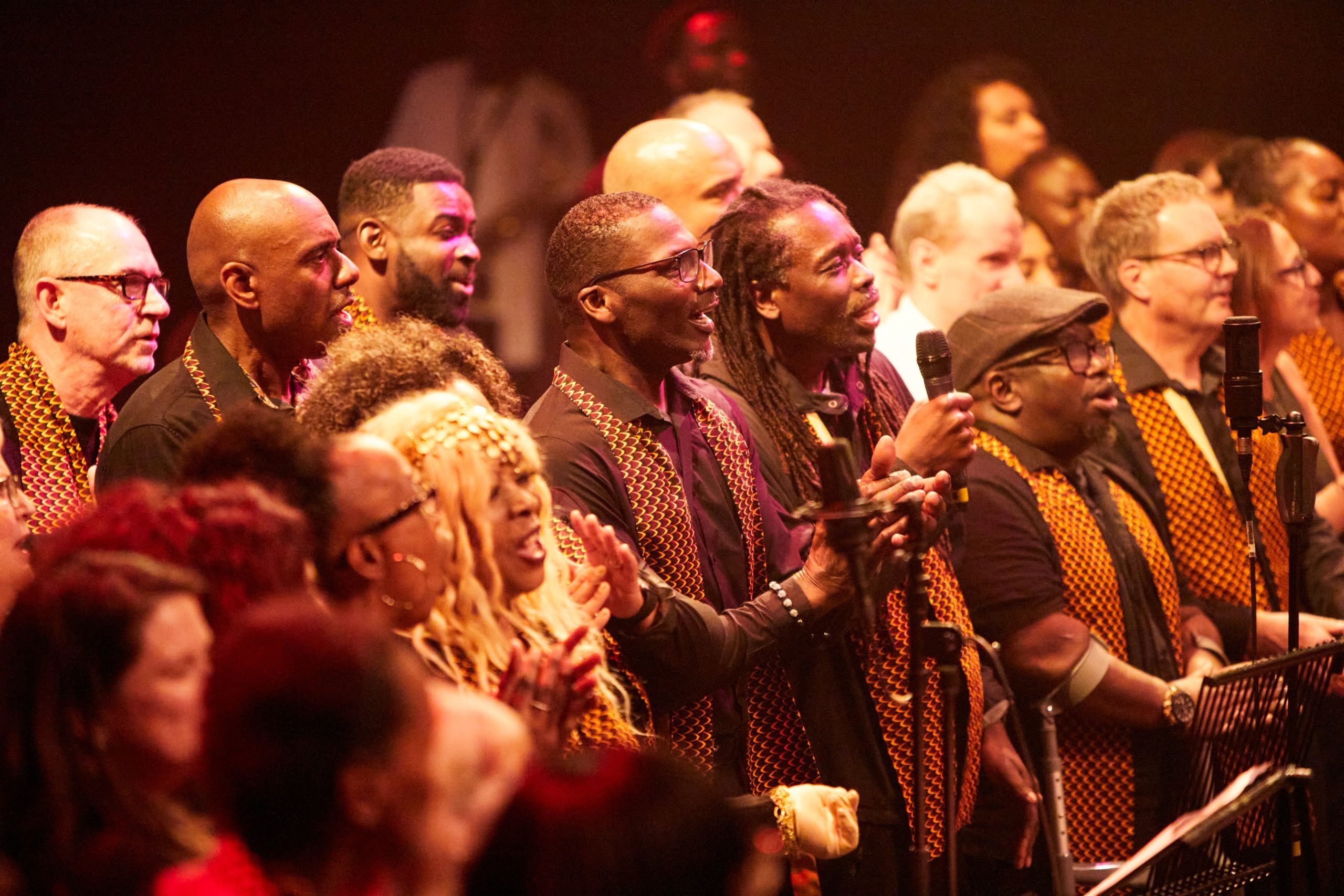 a group of people stood together performing/singing
