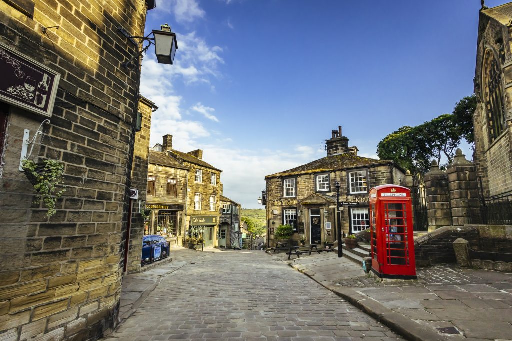 View of Haworth traditional cobbled street with old buildings and a old red phone box.