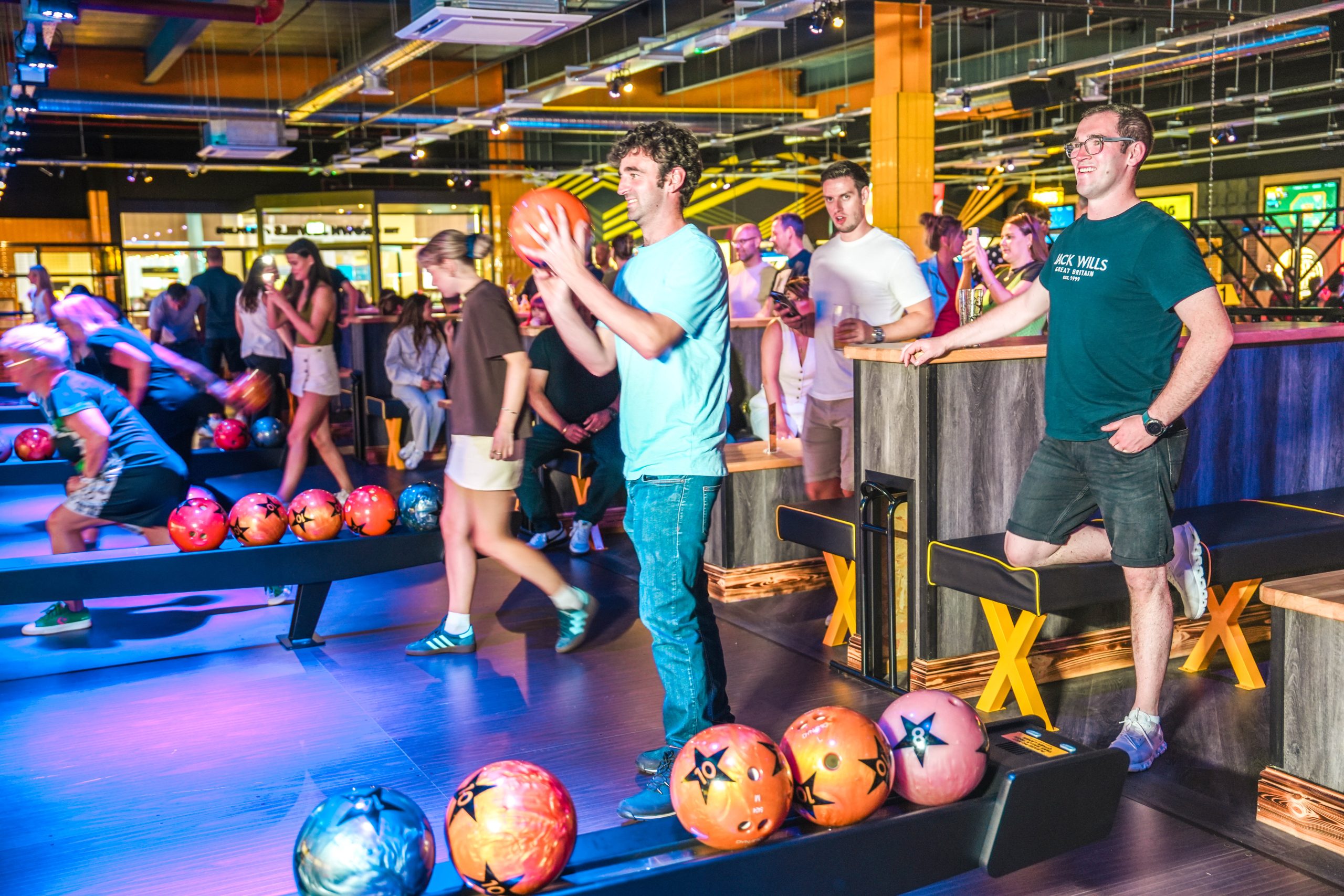 a busy bowling alley with neon lights