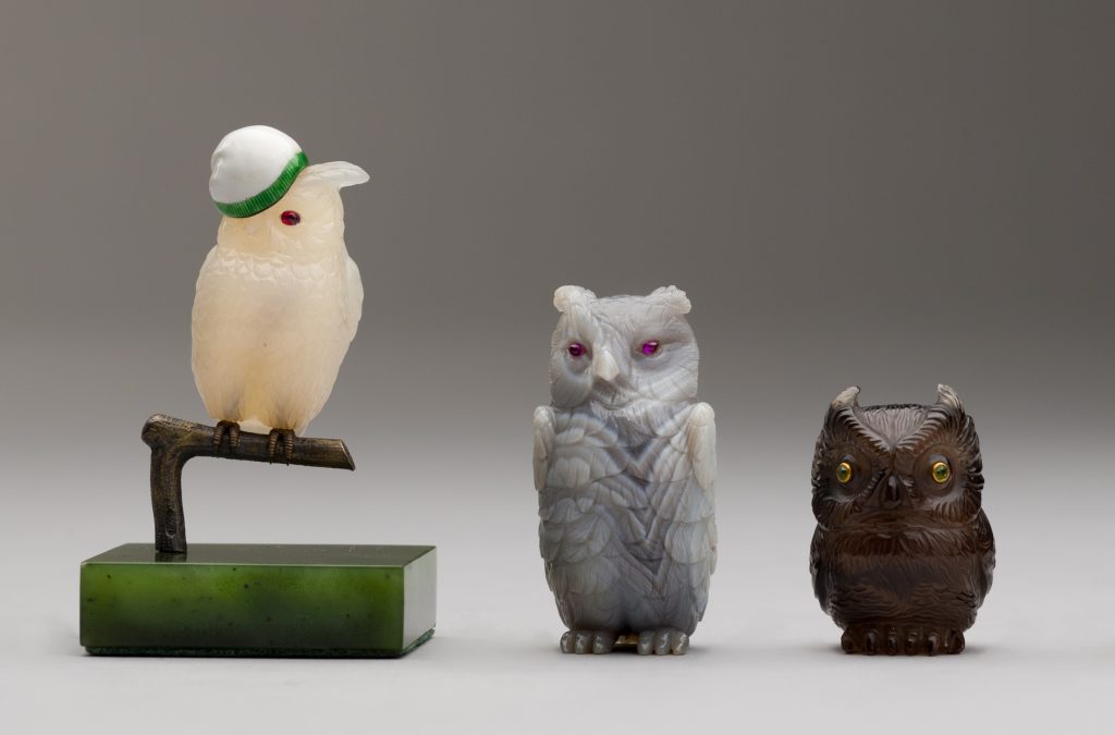 a close up photograph of three small glass owl ornaments