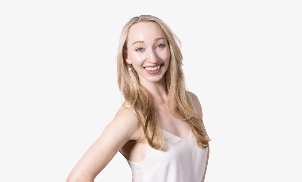 a portrait photo of a woman with long blonde hair, smiling at the camera