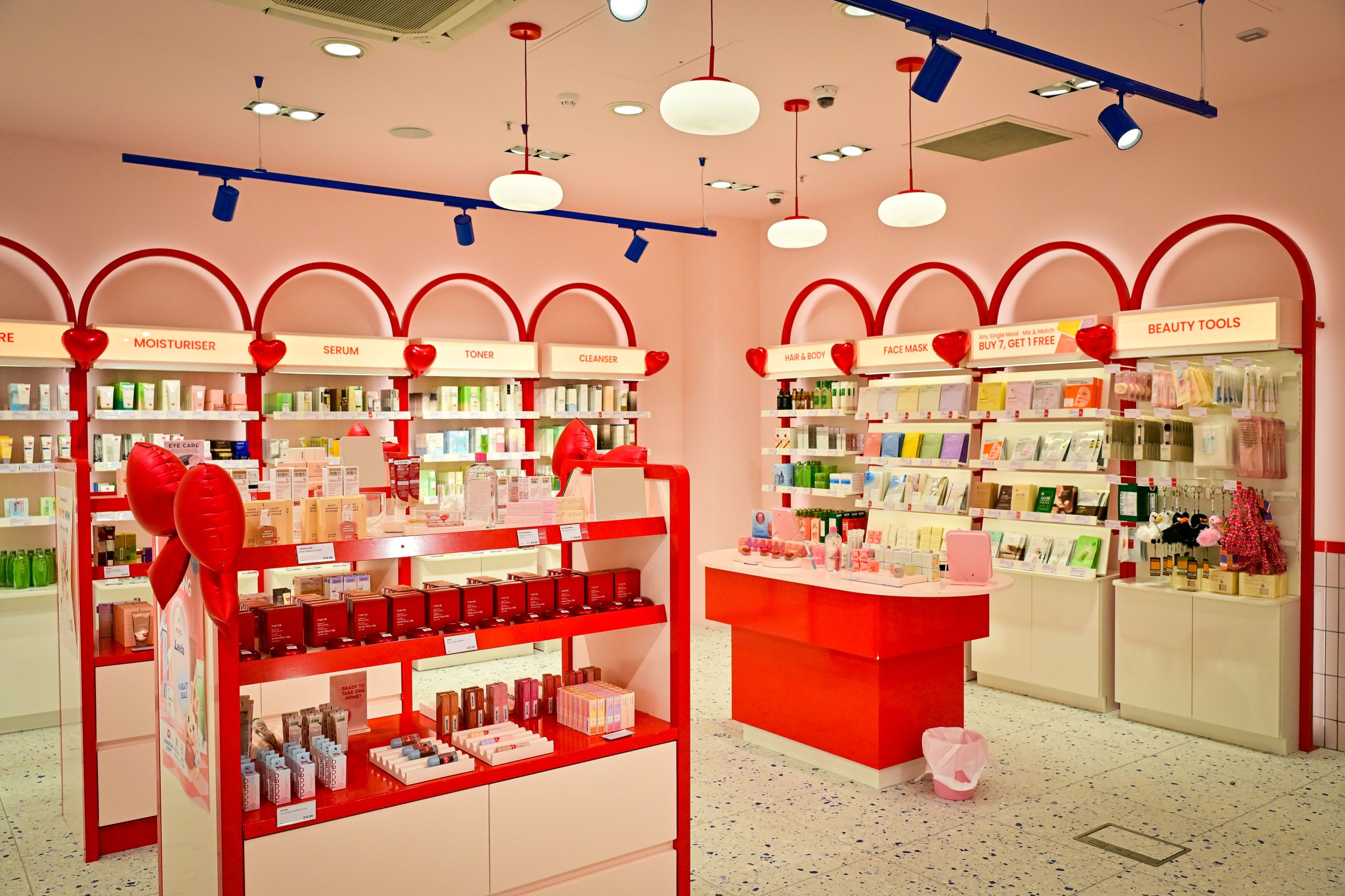 the interior of a makeup and beauty shop with wall shelving and stands in the middle filled with a variety of colourful bottles and jars