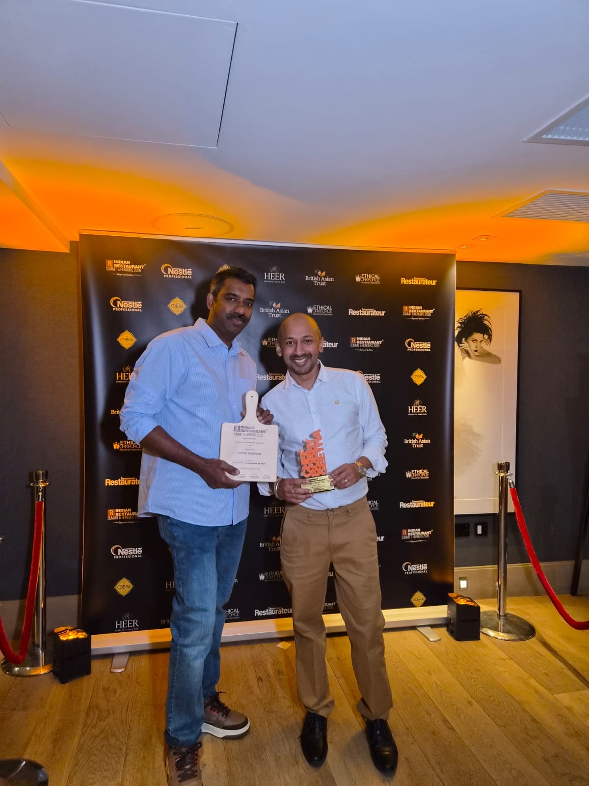two people holding awards