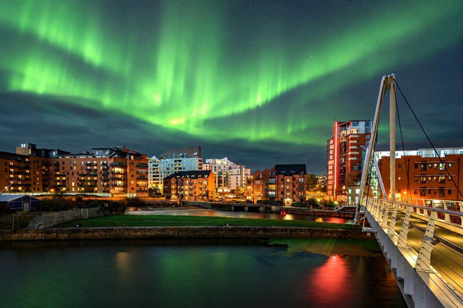 a photograph of the northern lights above a town skyline