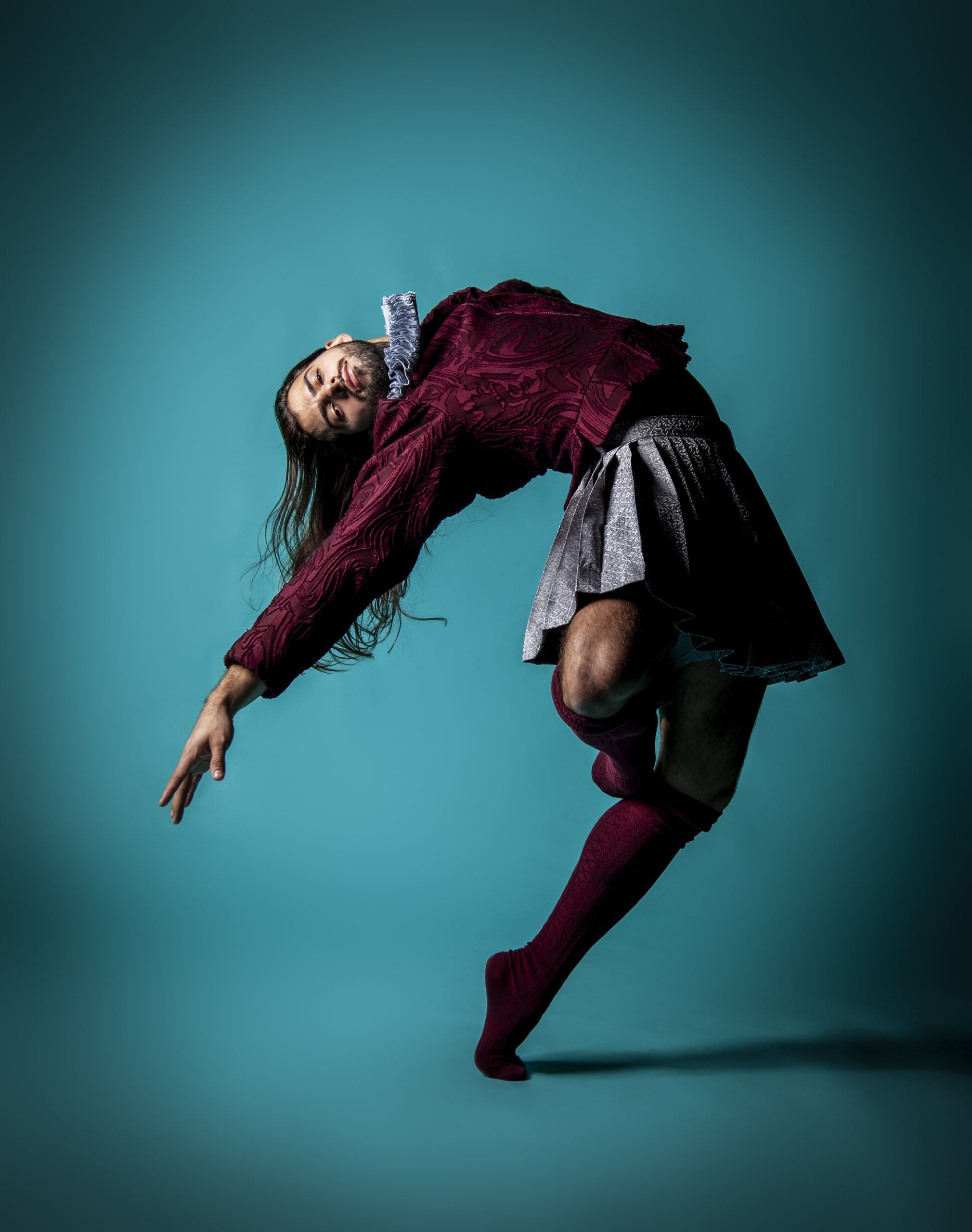 a portrait photo of a man in a tudor style costume dancing