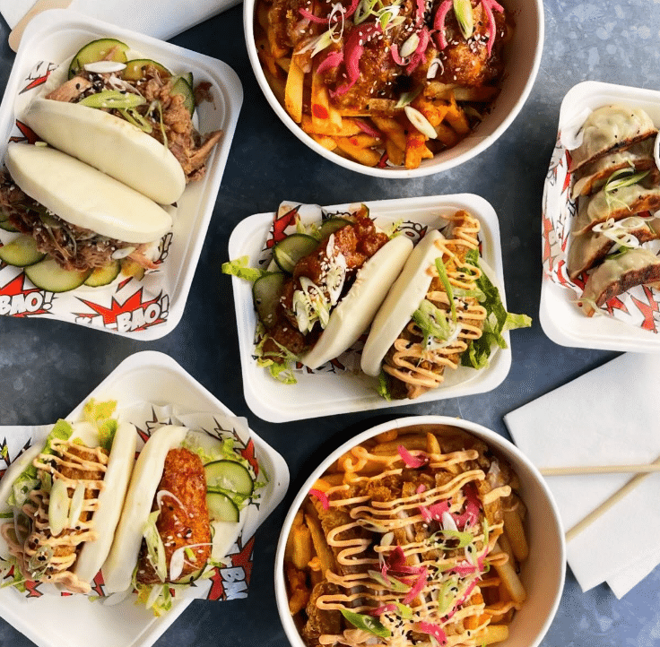 a top down view of a table filled with food in boxes and trays
