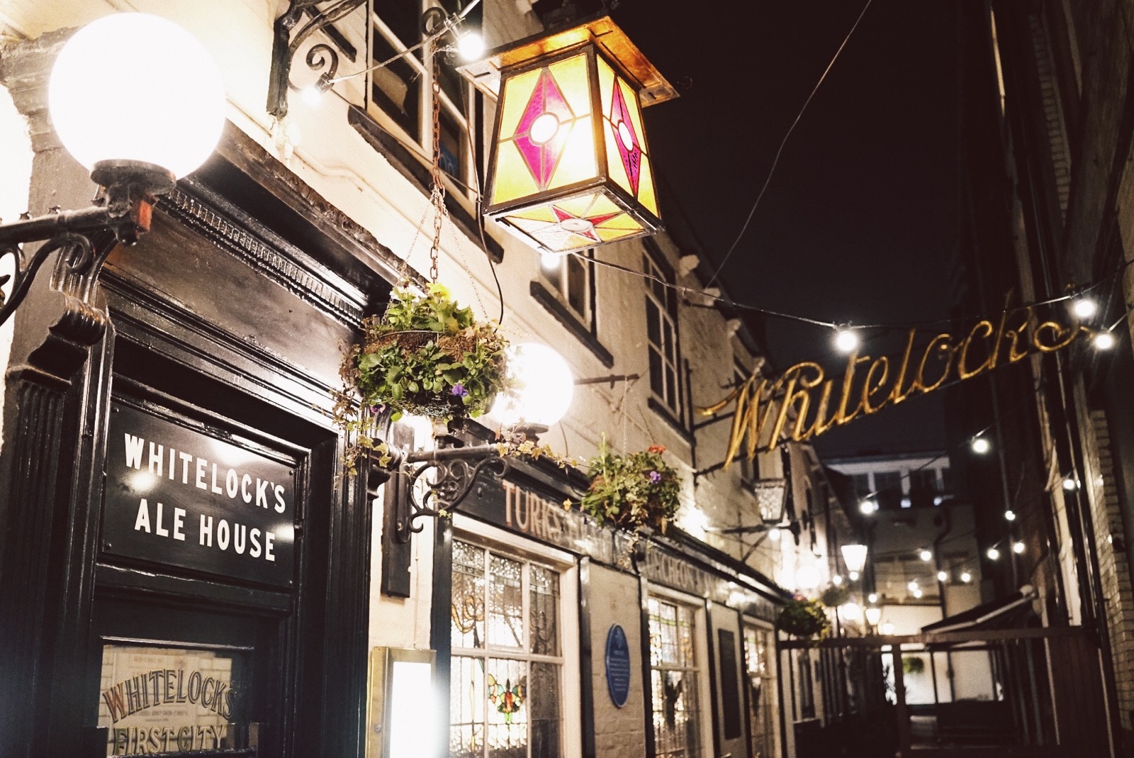 Exterior view of Whitelocks pub at night lit up and looking festive.